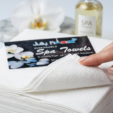 Close-up texture of JF disposable towels showing 55gsm absorbent material for salon hygiene use