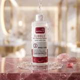 Bottle of active X Bubble Skin Cleaning Solution on a reflective surface with a blurred background