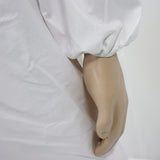 Mannequin leg wearing a white garment on a plain background